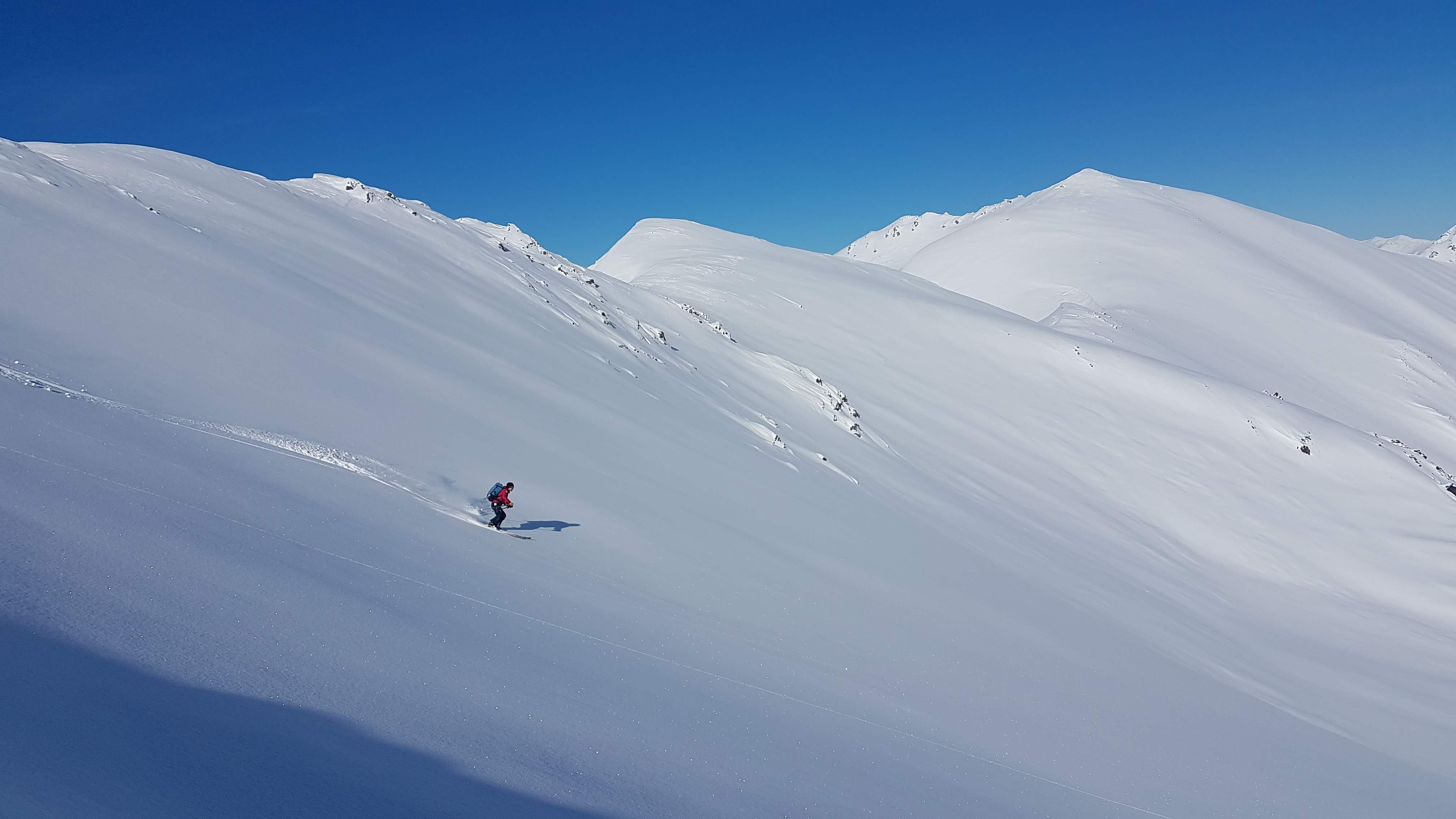 person skiing down snow covered mountain